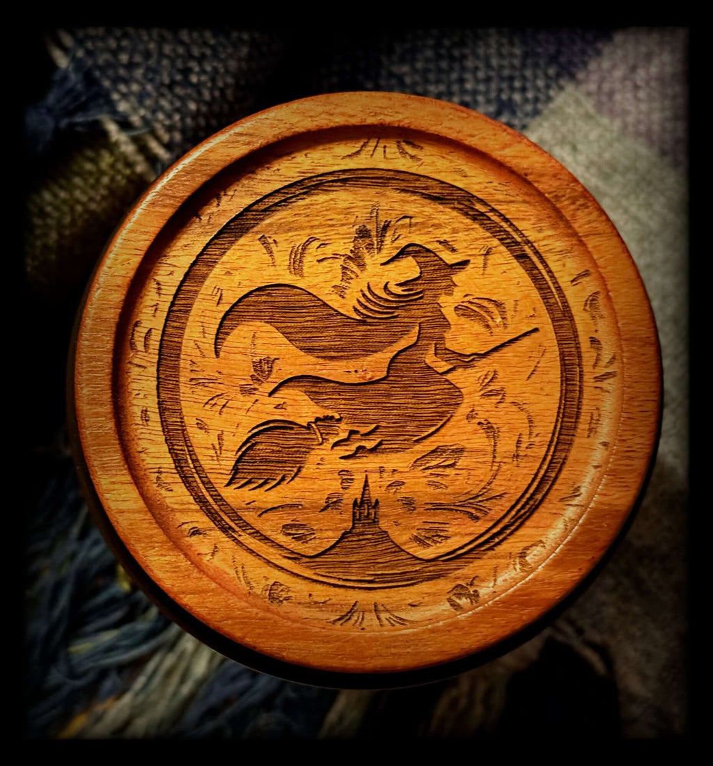 Image depicts an acacia wood lid engraved with a witch logo.